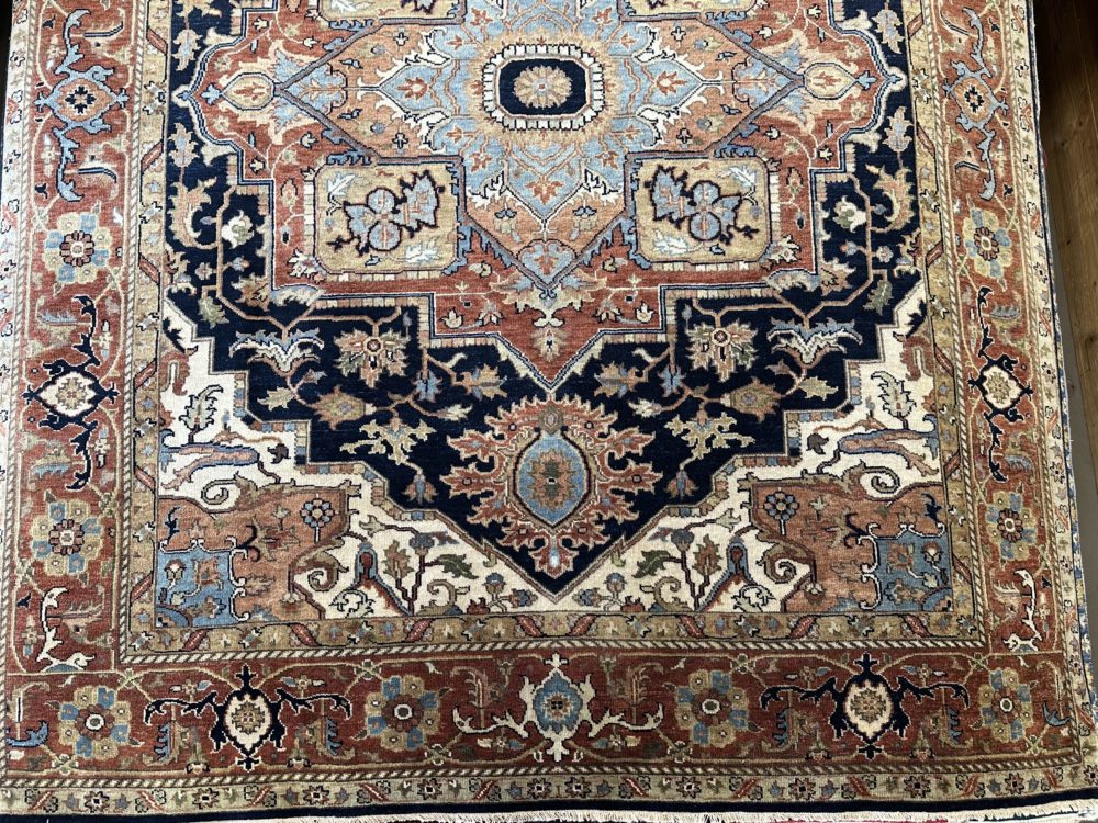 This hand knotted Indo Serapi rug lends a traditional feel to your favorite room. It carries a bold geo-floral design elements along with a pleasing balance of blue, natural and red colors.